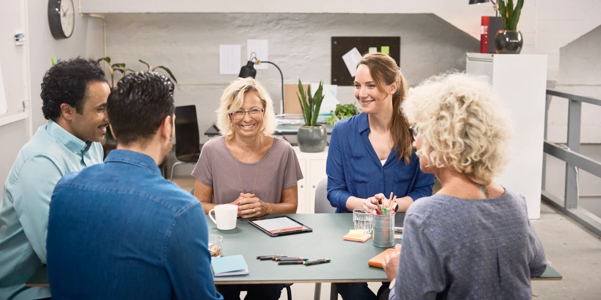 En grupp människor som sitter runt ett bord och pratar.