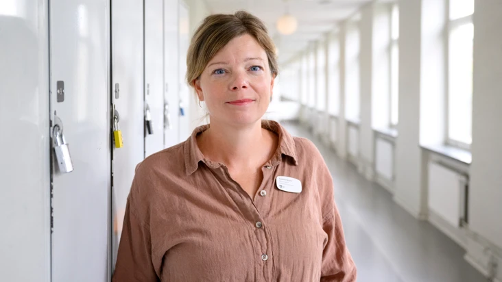 Porträtt av Susanne Eklund, fackligt ombud på Rålambshovsskolan, står i en skolkorridor.