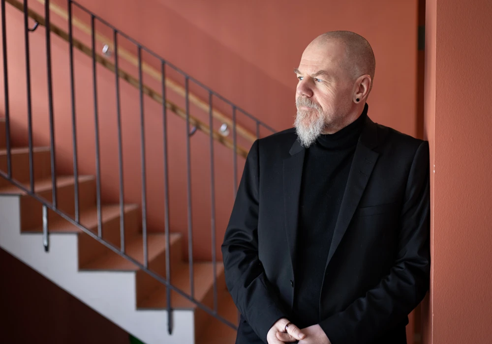 Forskaren Michael Rosander står i ett trapphus. Han forskar om mobbning mot chefer.