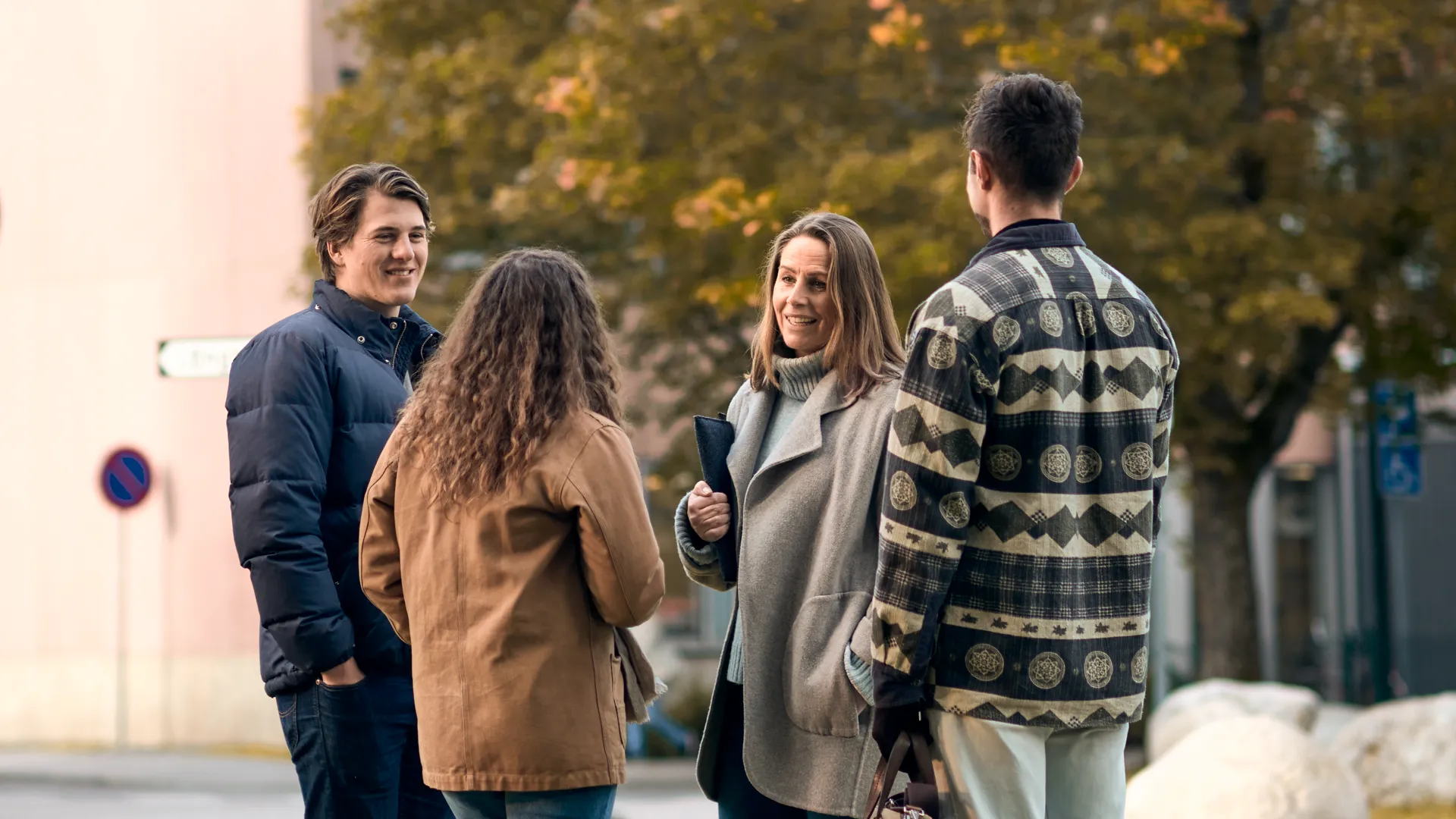 En grupp människor står utomhus och pratar.