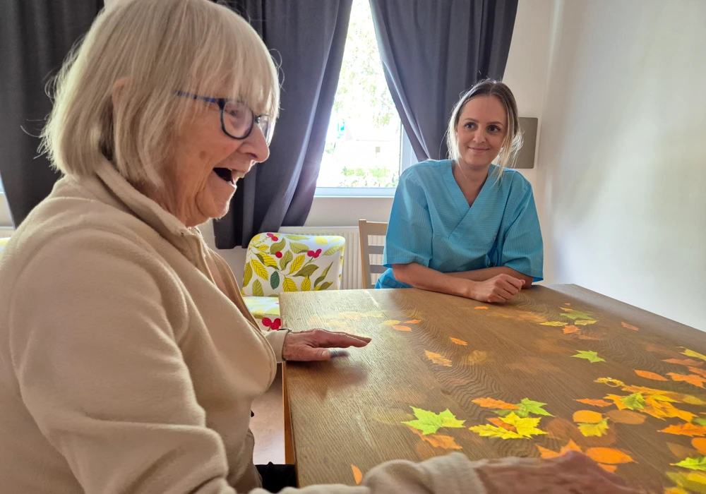 En undersköterska och en boende på Älandsgården spelar spel tillsammans.