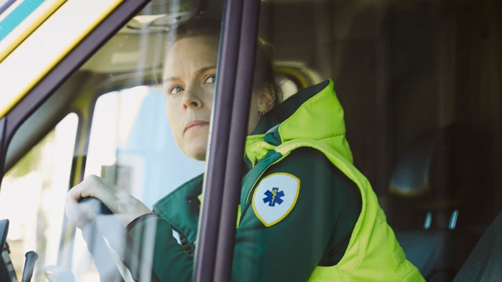 ambulansförare tittar oroligt ut genom fönstret på en ambulans.