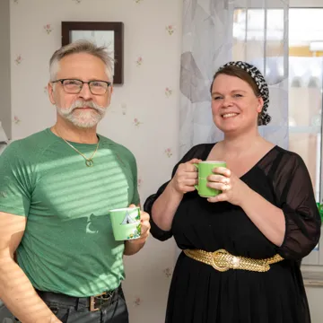 En manlig undersköterska och hans kvinnliga chef står i fikarummet och dricker kaffe.