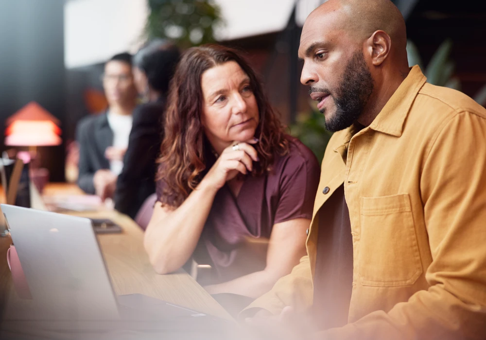 En chef och en medarbetare samtalar om arbetsanpassing.