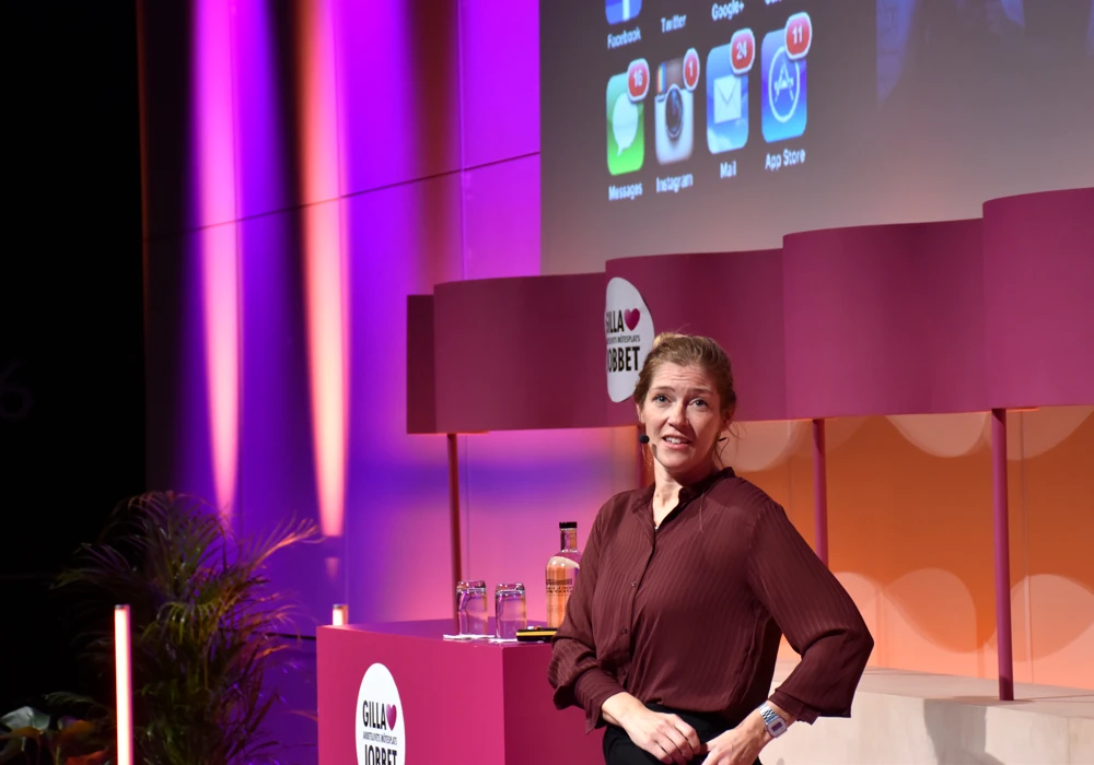 En kvinna står på en scen framför en skärm, tema hjärnvila.