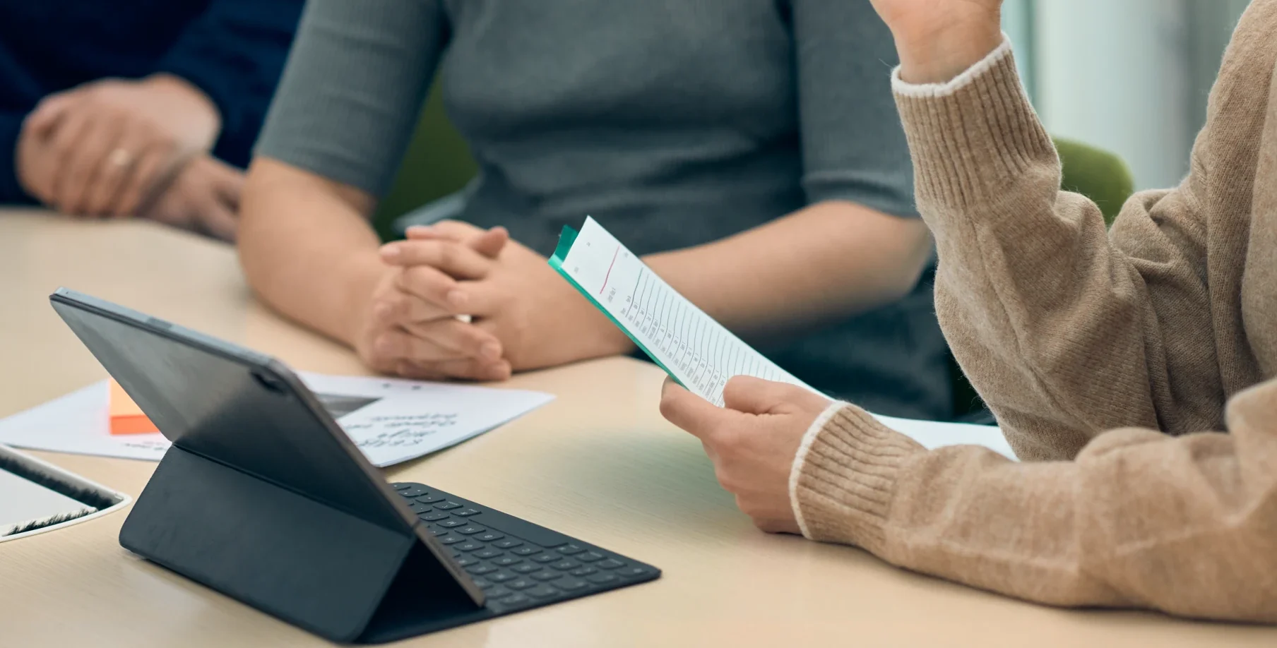 En grupp människor som sitter runt ett bord med en bärbar dator