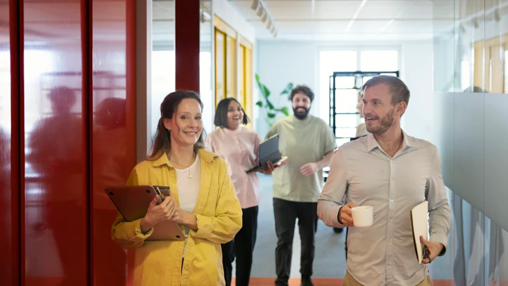 En grupp m&auml;nniskor som g&aring;r i en korridor.