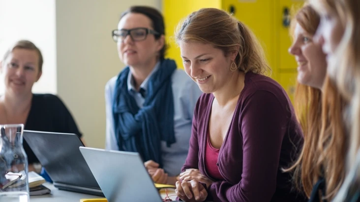 fyra personer sitter vid ett bord på ett möte.