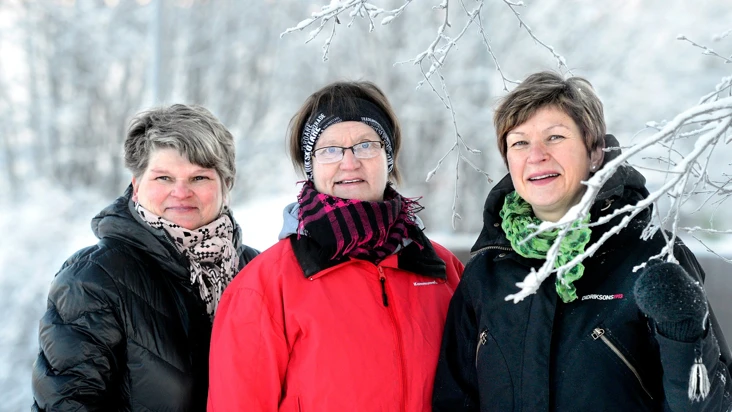 Tre kvinnor st&aring;r bredvid varandra i sn&ouml;n.