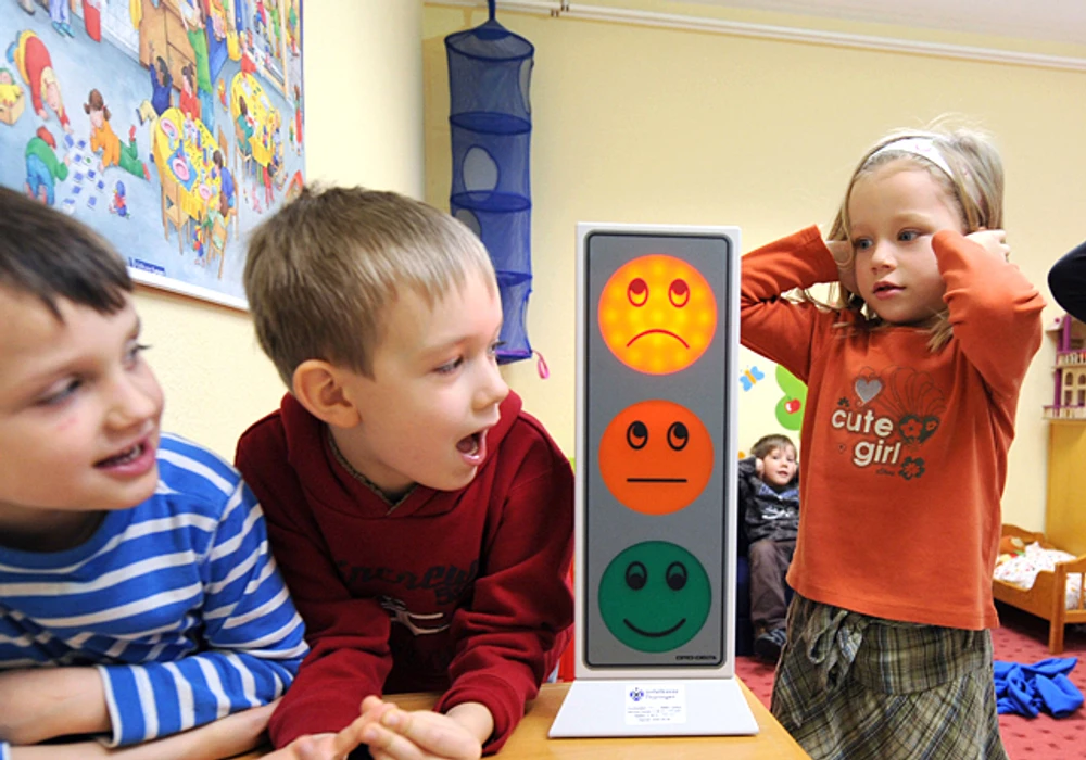 Några barn i förskolemiljö. Två håller för öronen.