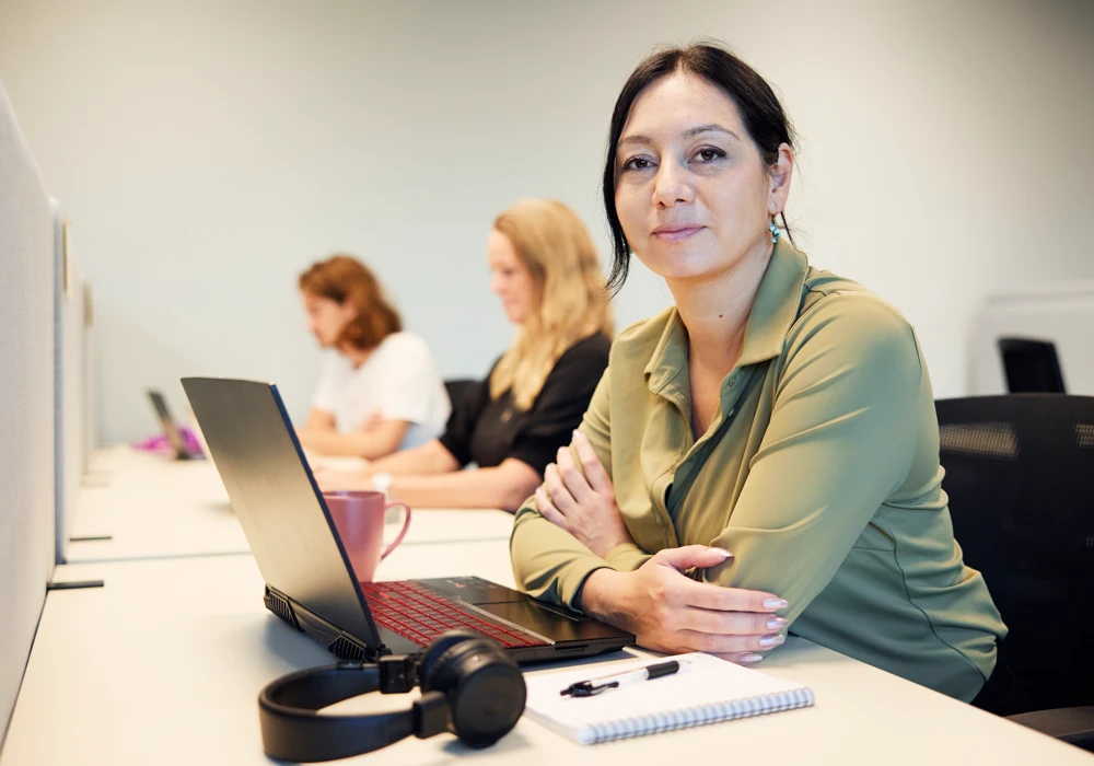 En kvinna sitter framför en bärbar dator.