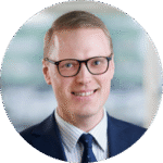 En man i kostym och slips poserar för en bild.