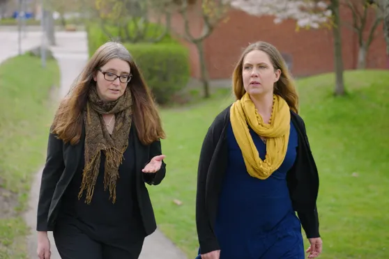 N&aring;gra kvinnor som g&aring;r p&aring; en trottoar.