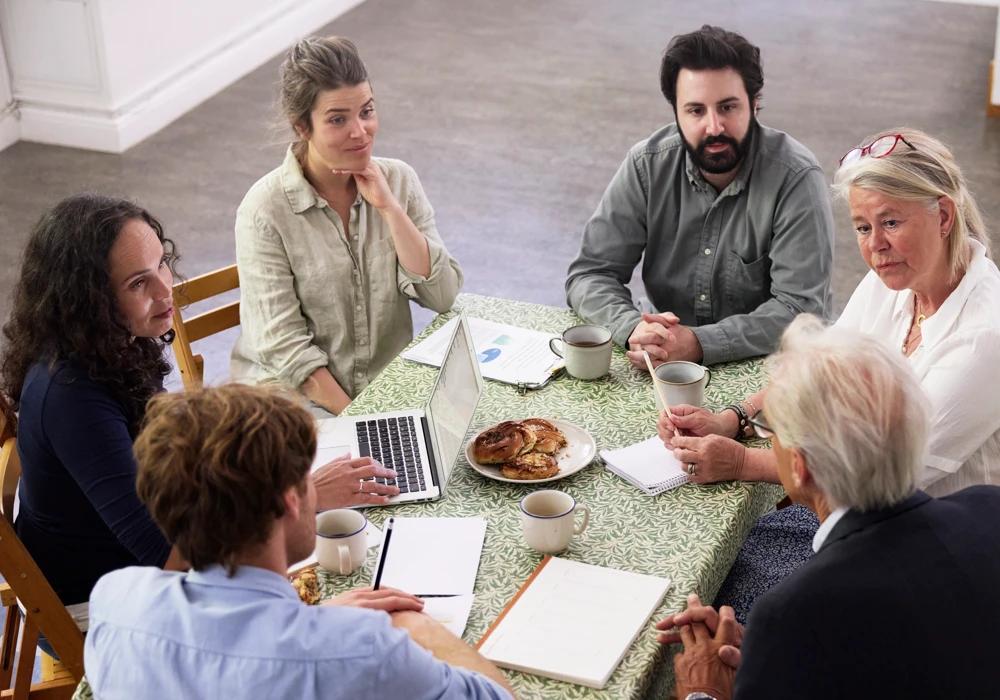 En grupp människor i blandade åldrar har möte.