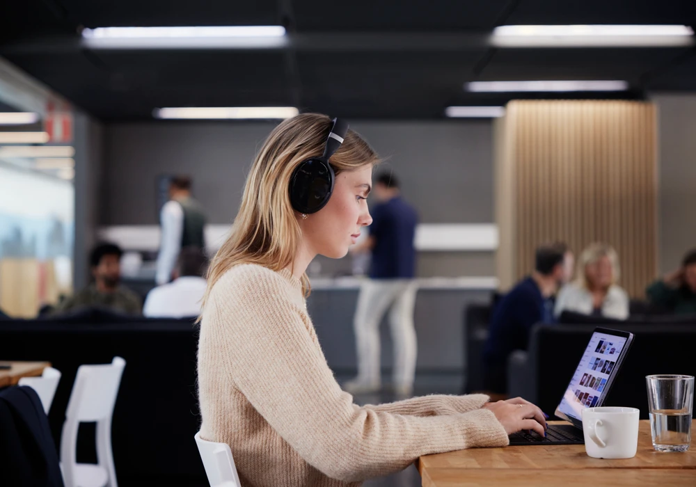 En person med hörlurar jobbar vid en dator.