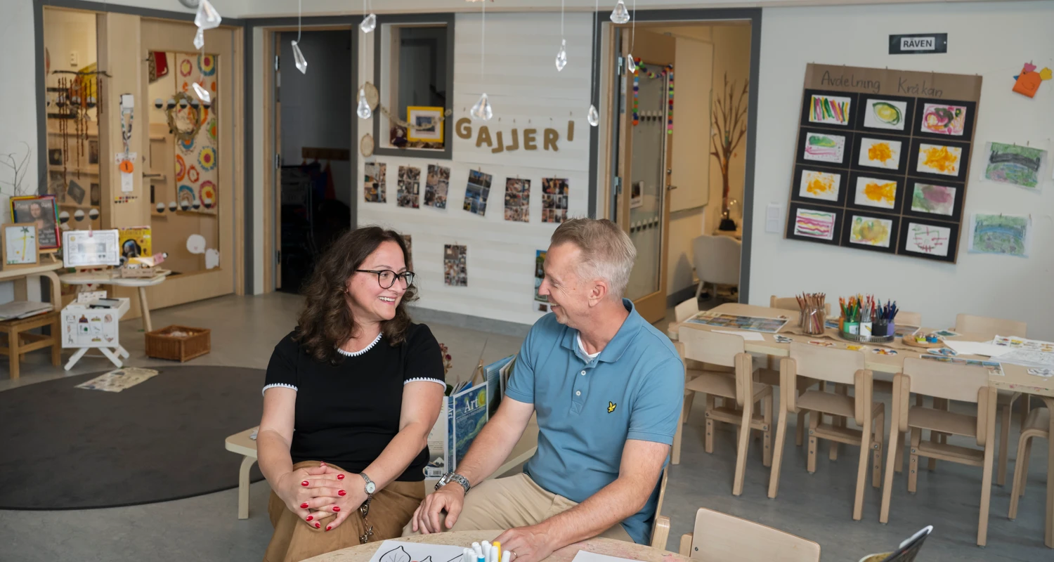 En man och en kvinna sitter i ett rum på en förskola.