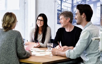 En grupp m&auml;nniskor som sitter runt ett tr&auml;bord.