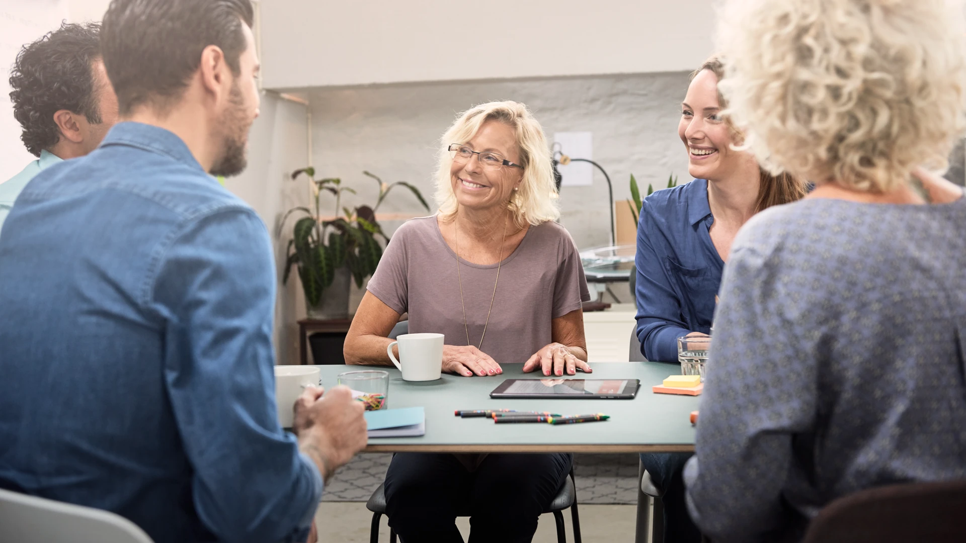 En grupp människor som sitter runt ett bord och pratar.