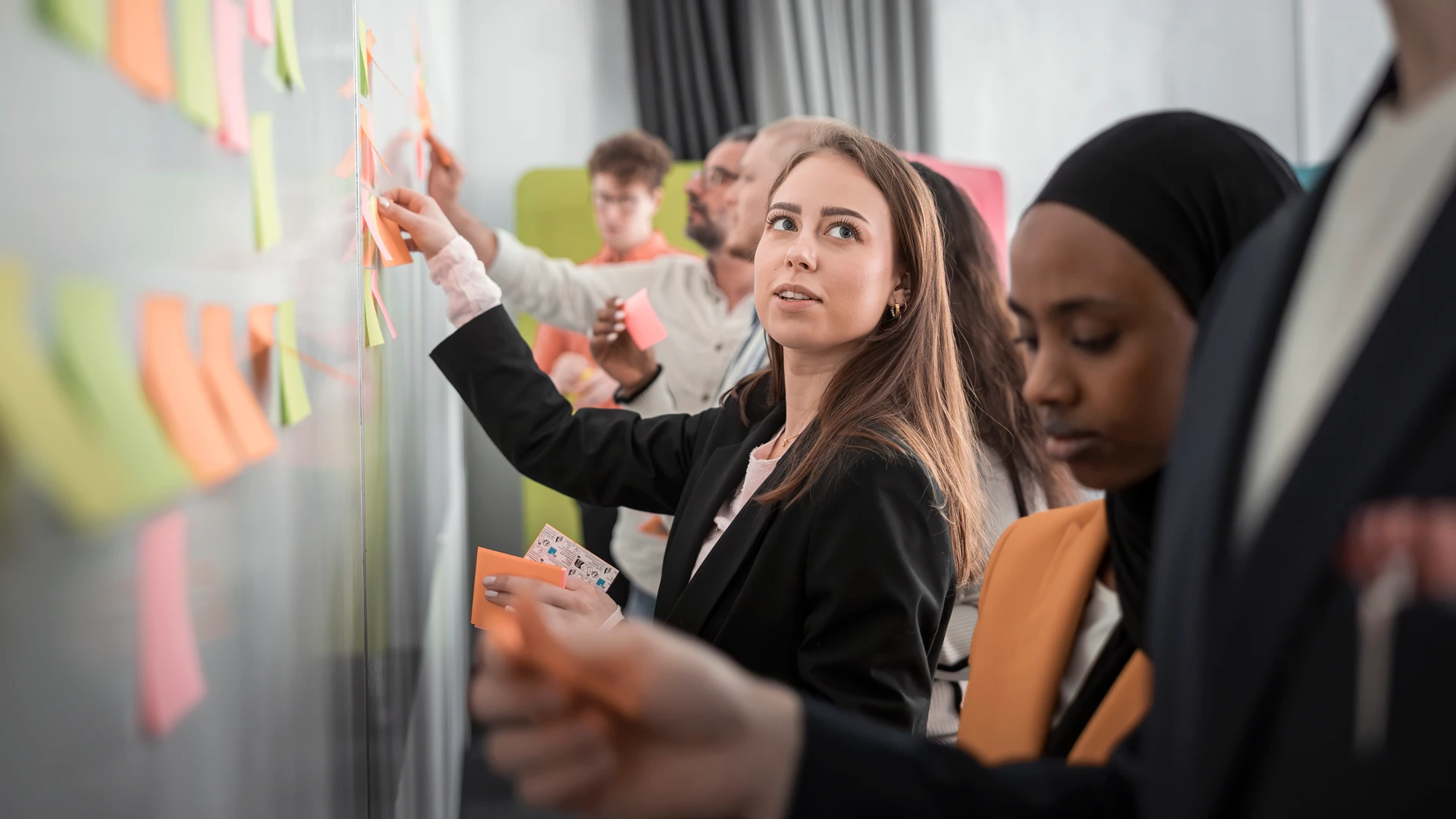 En grupp människor som står runt en whiteboardtavla.