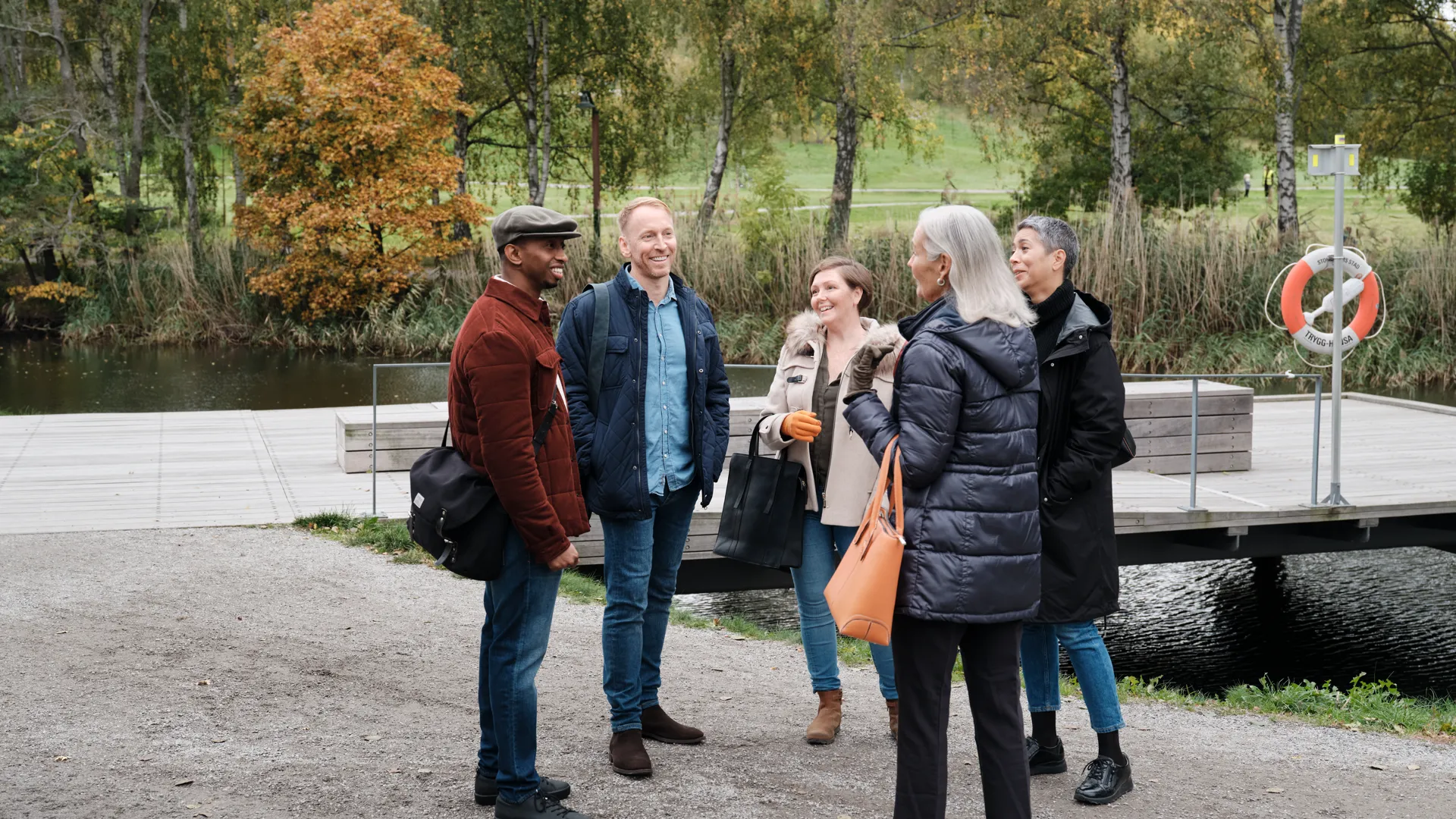 En grupp kollegor står utomhus och pratar med varandra.
